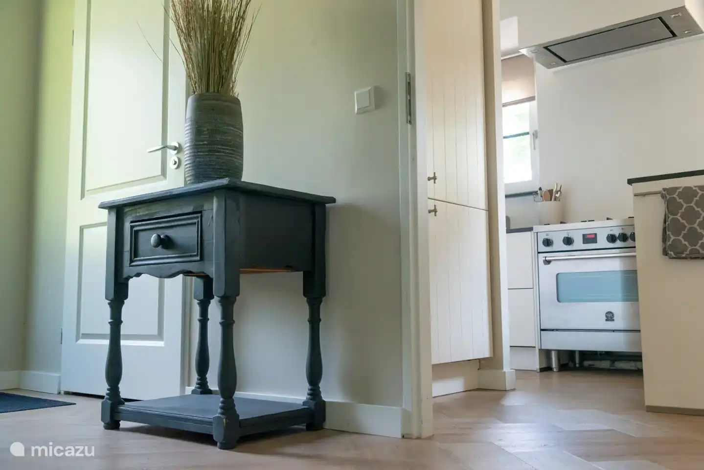 Offene Küche mit Gasherd und Über-/Grill von der Eingangshalle aus gesehen.