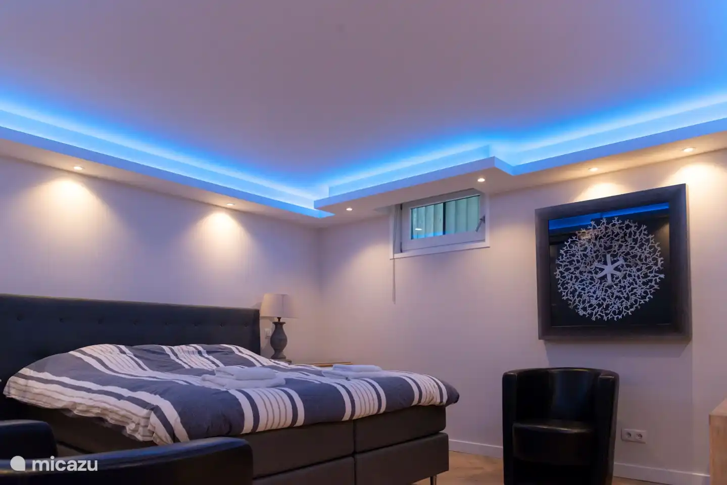 Hauptschlafzimmer mit eigenem Bad im Untergeschoss mit eingeschalteter blauer LED-Beleuchtung.