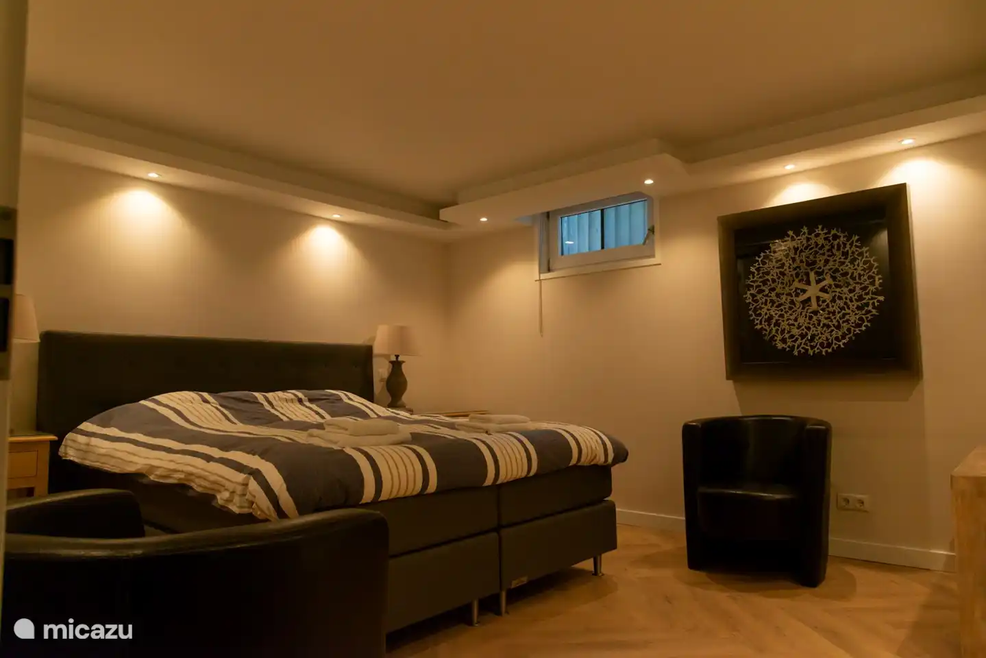 Hauptschlafzimmer mit eigenem Bad im Untergeschoss mit normaler Beleuchtung.