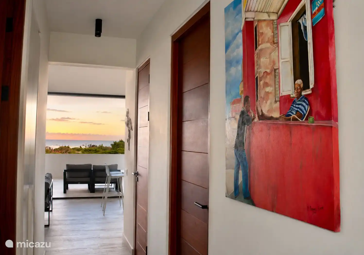 Entrada con arte local y vistas al océano del atardecer