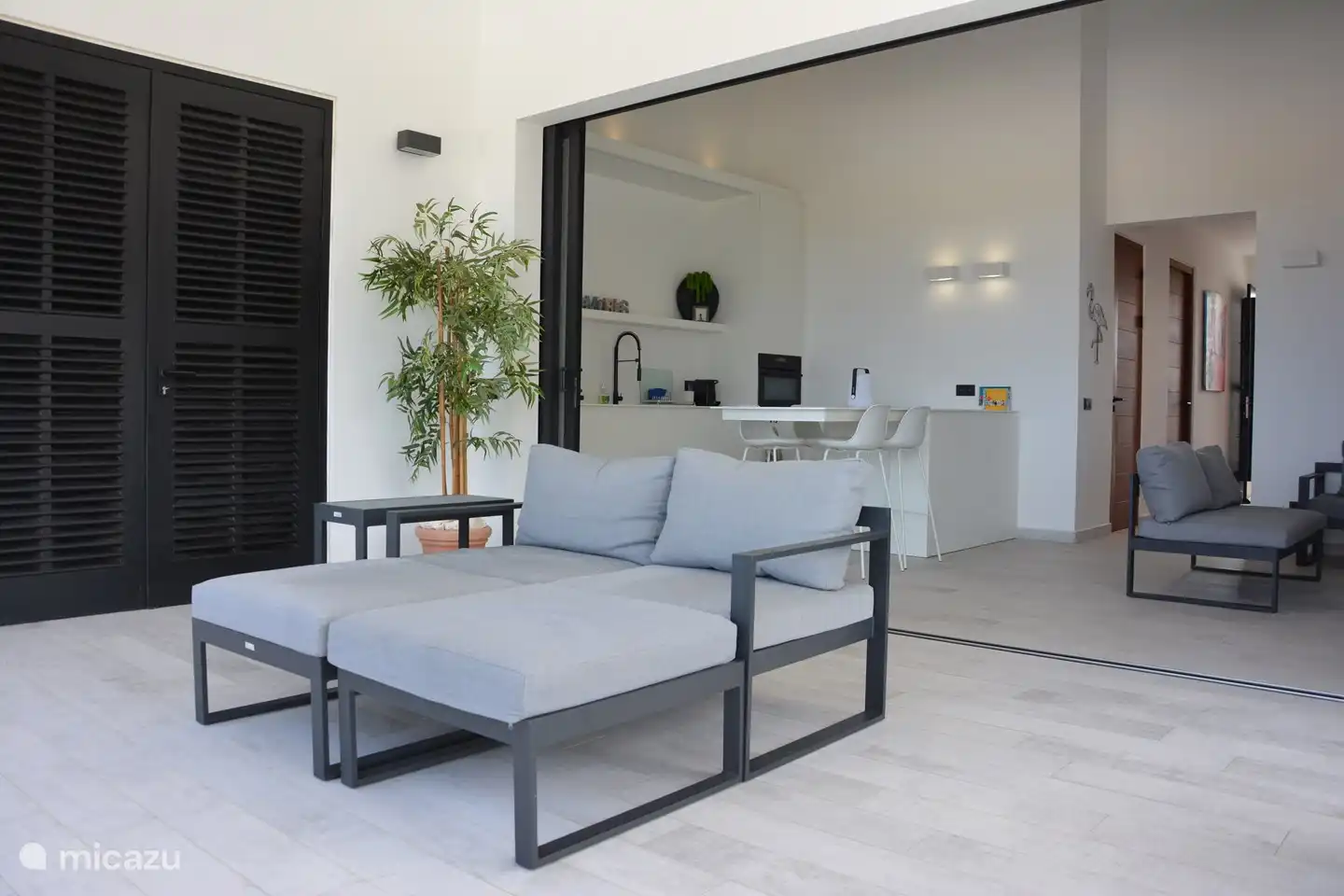 Lounge-Betten auf der Terrasse von 30 m2 mit vollständig eingezogenen Schiebetüren zum Wohnzimmer und zur offenen Küche