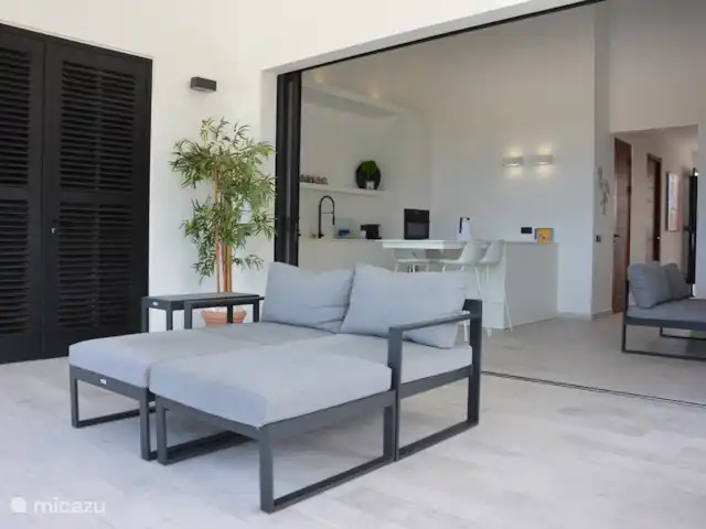 Blue Bay Penthouse REEF 5 OCEAN VIEW huren in Curaçao, Curacao-Midden, Willemstad - appartement Lounge beds op terras van 30 m2 met geheel  ingeschoven schuifdeuren naar de woonkamer en open keuken