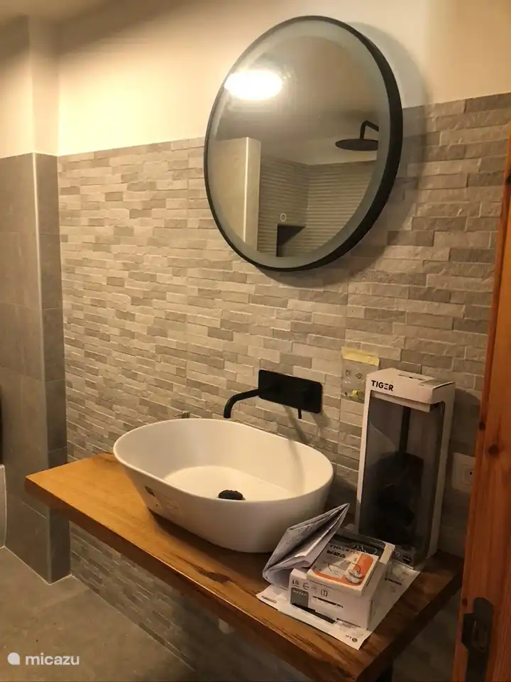 Ein Spiegel mit Beleuchtung über dem Waschbecken