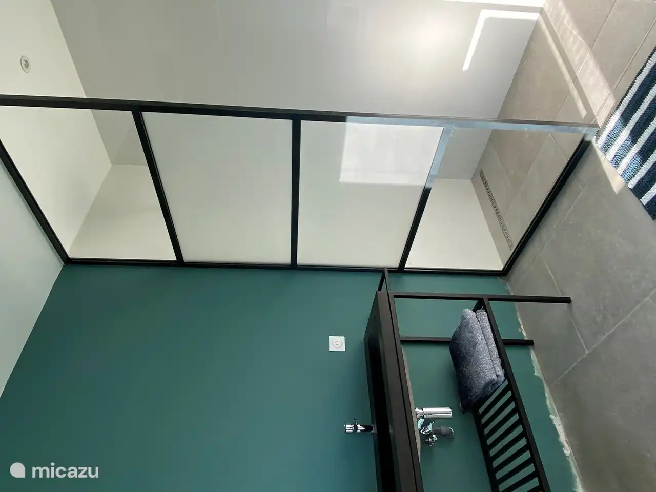 Zwei Badezimmer (ein großes und ein kleines), beide mit Regendusche und Waschbecken.