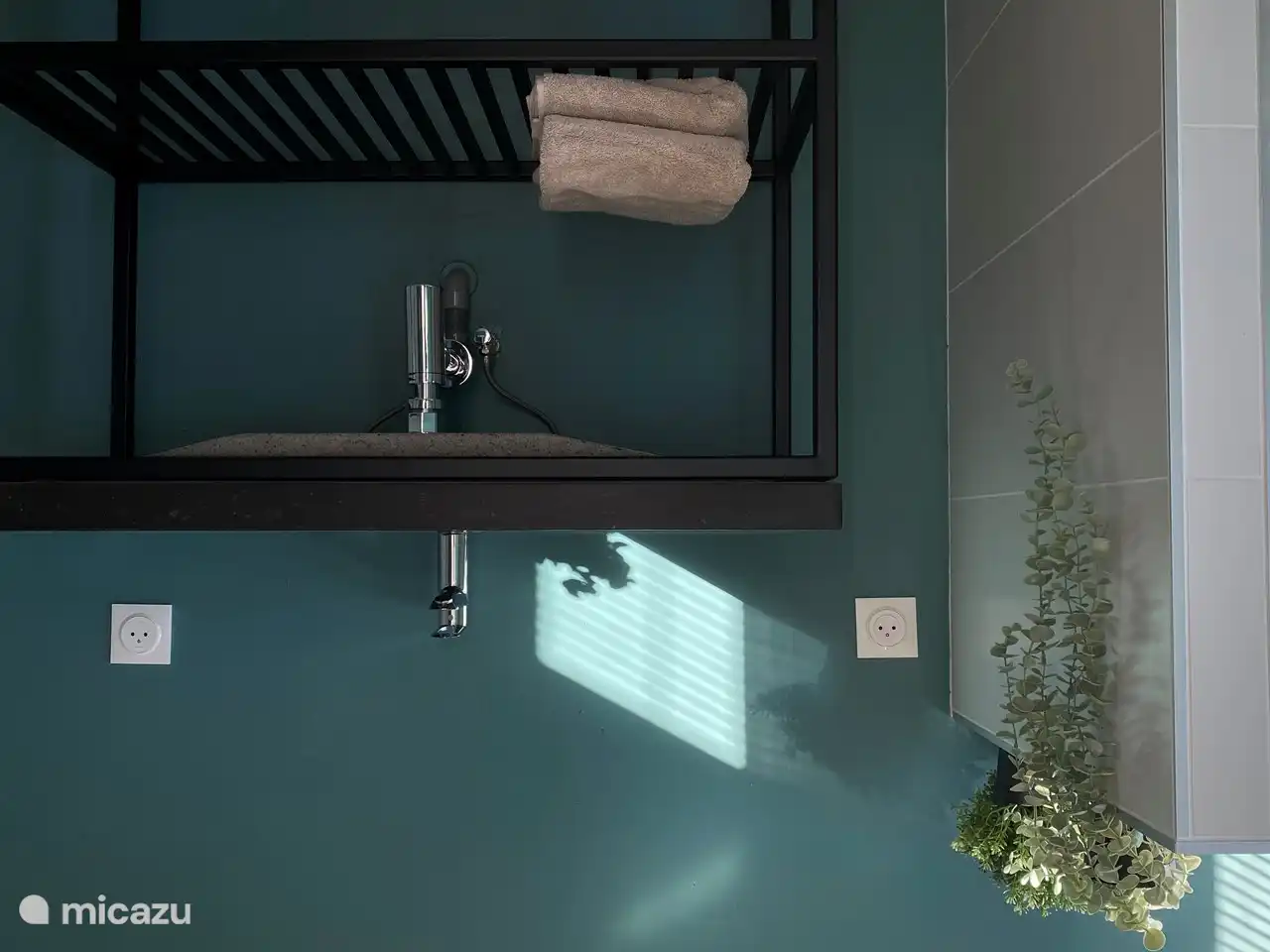 Ein großes und ein kleines Badezimmer, beide mit den gleichen Farbakzenten