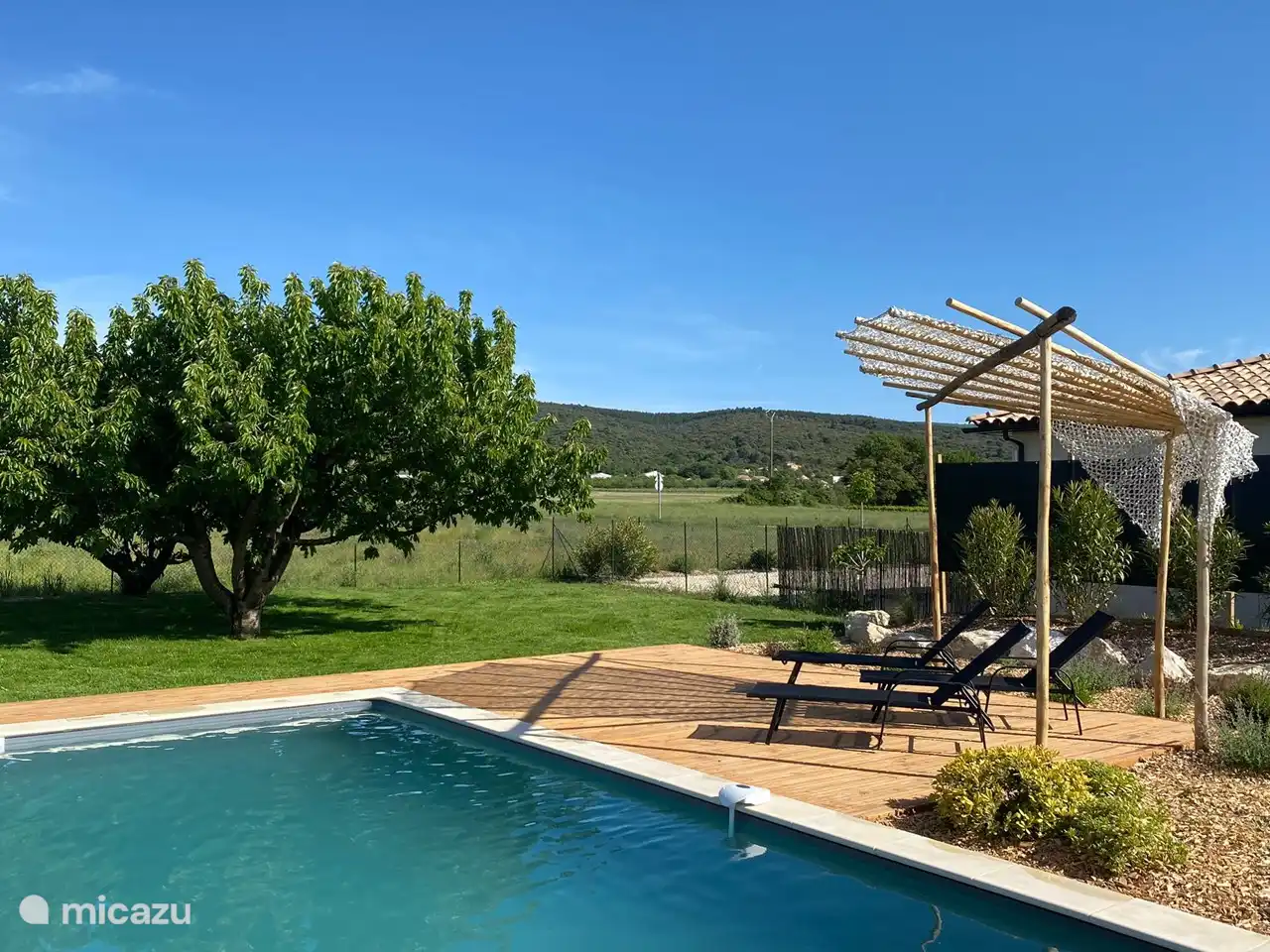 Auf der Holzterrasse haben wir für Schatten gesorgt. Im Hintergrund sieht man einen Sichtschutz zwischen Marasco und dem Nachbarhaus, in Zukunft werden die Oleander groß genug als Greenscreen sein