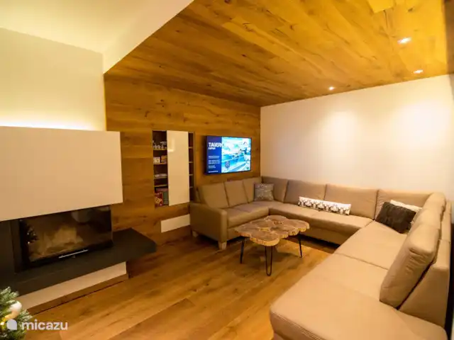 Chalet Murmi | Autriche, Salzburgerland, Uttendorf - chalet Coin salon avec canapé spacieux, TV, jeux de société et cheminée.