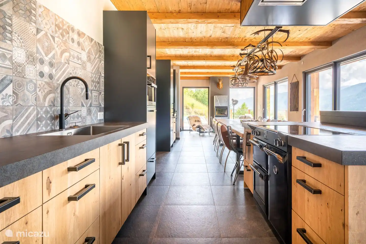 La cuisine de luxe est équipée d'un bar avec tabourets de bar et d'une table pour 14 personnes.