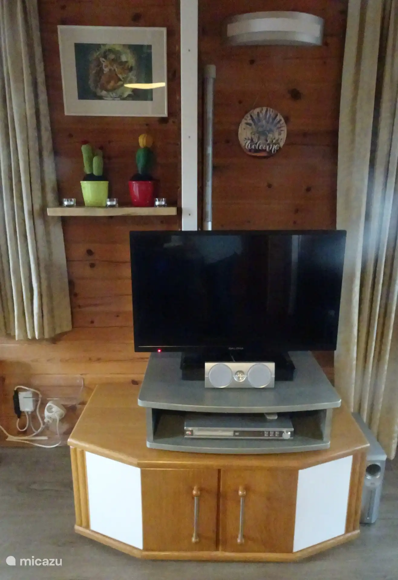 TV sur platine vinyle avec lecteur DVD au coin salon. Dans le meuble TV, il y a des jeux pour les petits enfants, des livres et des DVD