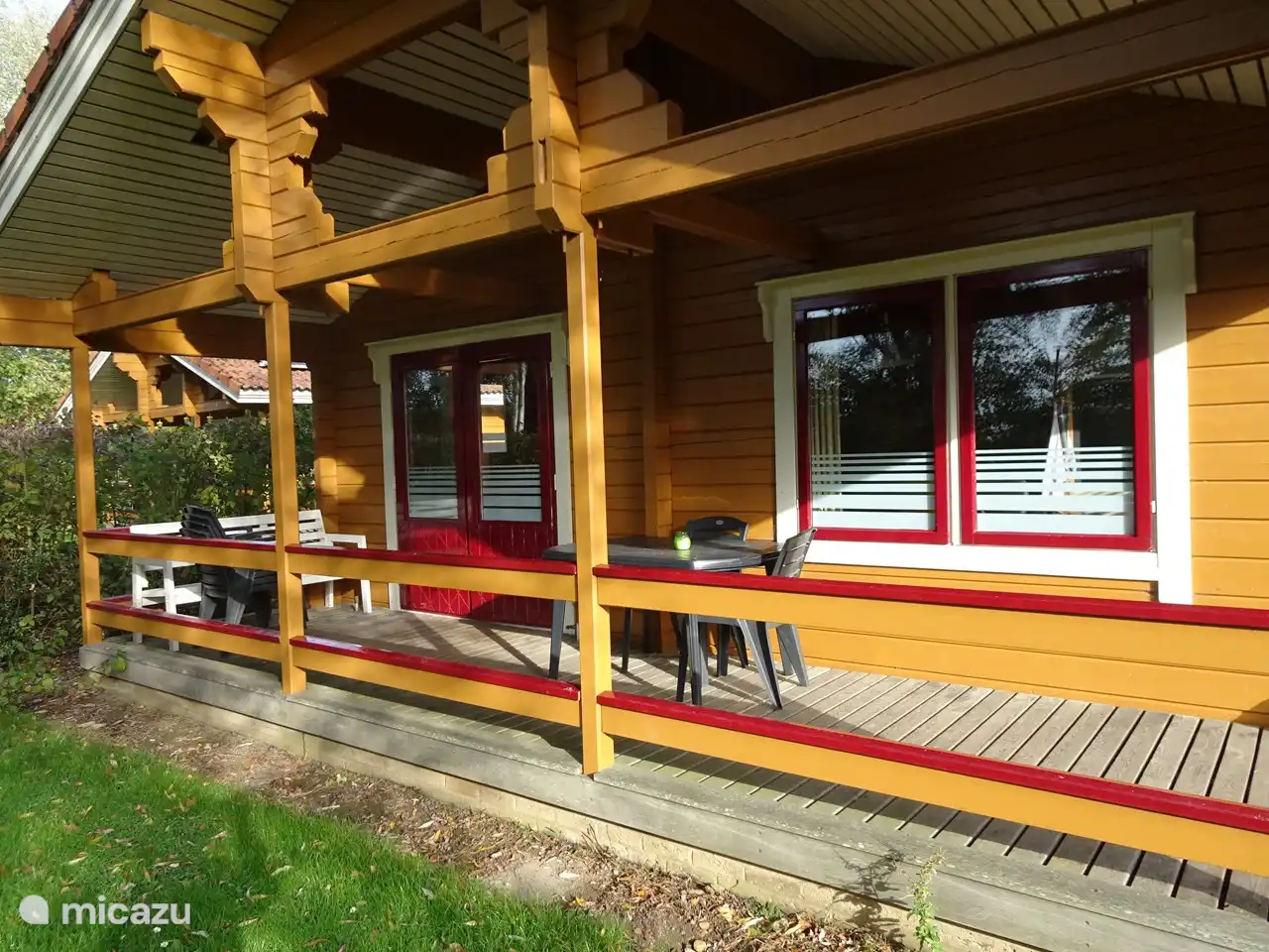 Véranda avec salon de jardin : table, 6 chaises et un canapé. Les oreillers se trouvent dans le placard supérieur de la chambre du milieu. 2 chaises longues se trouvent dans la chambre à côté du placard