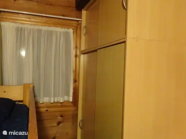 Chalet finlandais, dans un parc avec piscine | Pays-Bas, Overijssel, Gramsbergen - maison de vacances Belle grande armoire double suspendue avec portes coulissantes, de sorte que vous pouvez facilement l’atteindre. Le matelas du lit de camping se trouve derrière le lit superposé.