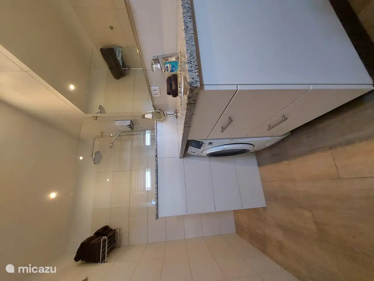 Die Waschmaschine mit Trockner befindet sich im Badezimmer. 