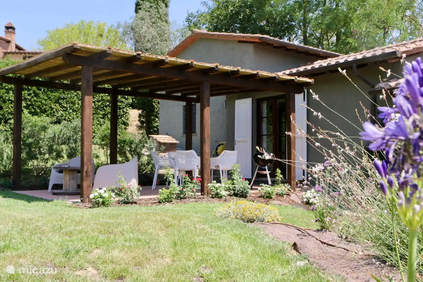 Terraza cubierta con vistas a la piscina y las montañas.