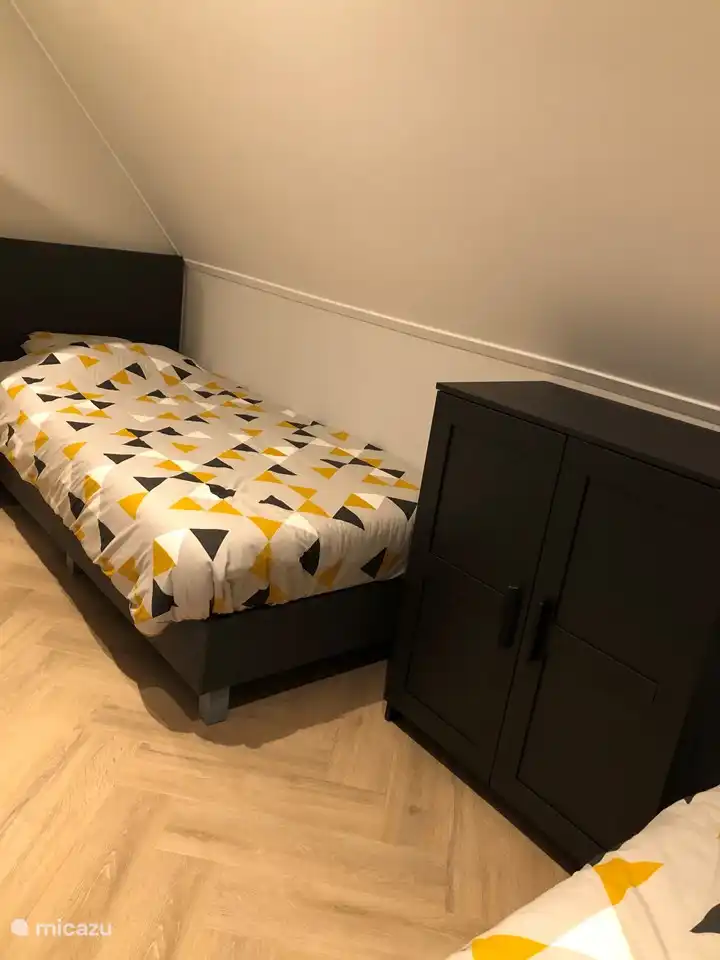 Schlafzimmer mit 2 Einzelbetten, Kleiderschrank und 2 Liegestühlen