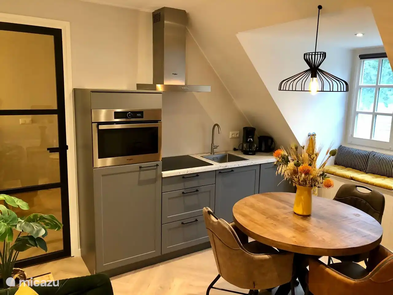 Küche mit Kombi-Mikrowelle, Induktionskochfeld, Kühlschrank mit Gefrierfach, Geschirrspüler, Senseo-Kaffeemaschine und Wasserkocher