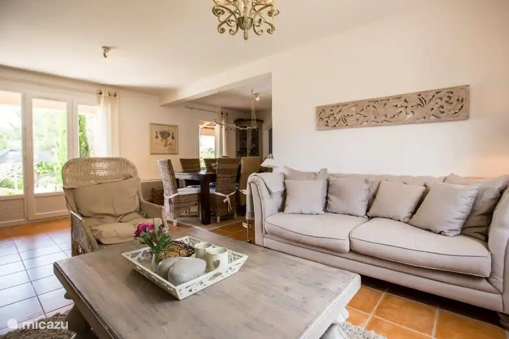 Wohnzimmer mit Terrassentüren zum Garten und Pool