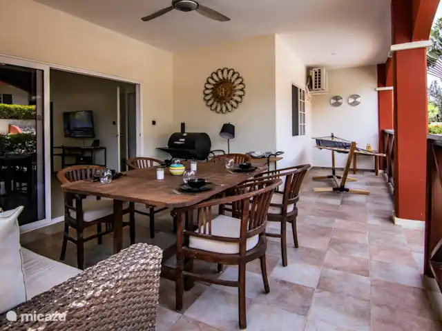 Chicos Seru Hulanda Resort en Curazao, Curazao Centro, Abrahamsz - apartamento La terraza cubierta del lado de la piscina tiene un comedor con 6 sillas y una hamaca y barbacoa.