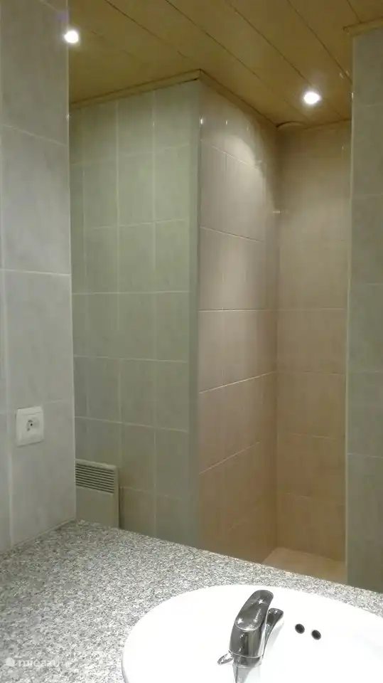 Das Badezimmer hat auch eine ebenerdige Dusche