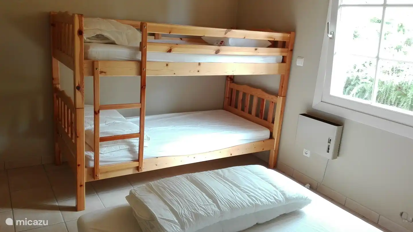 Dieses Schlafzimmer verfügt über ein Etagenbett und ein Boxspringbett