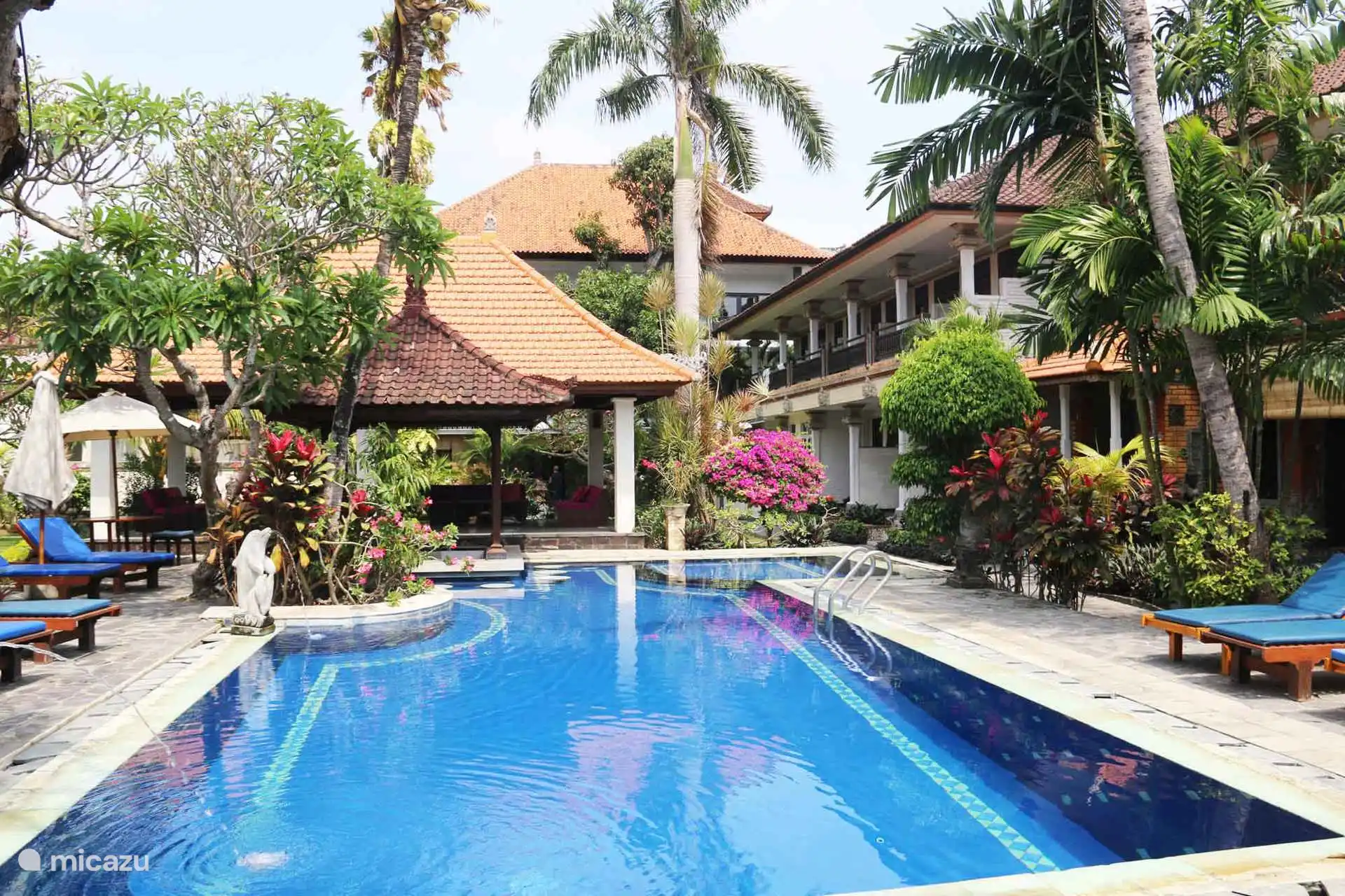 Swimming pool with children's pool with sun loungers.