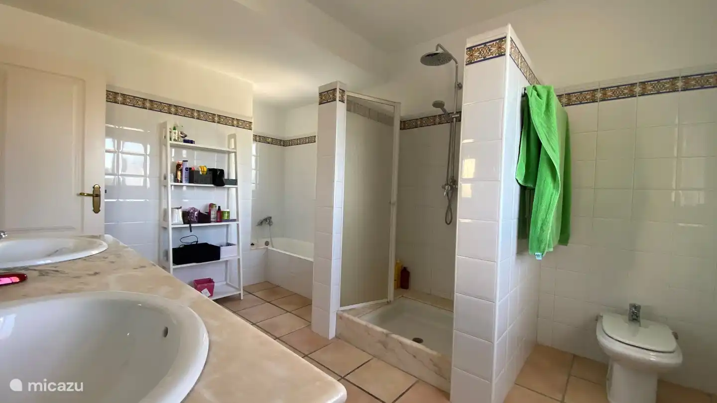 Very spacious bathroom with rain shower, bath, 2 sinks and toilet.