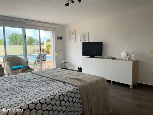 CasaSolymar en España, Costa Blanca, Moraira - villa Gran habitación 1 en la planta baja con vista a la piscina. TV con Google Chromecast, puede transmitir desde cualquier dispositivo inteligente o PC.