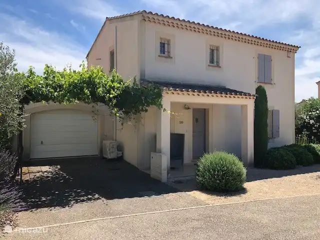 Vor dem Haus mit Garage und Parkplatz mit überdachter Pergola für Autos im Schatten