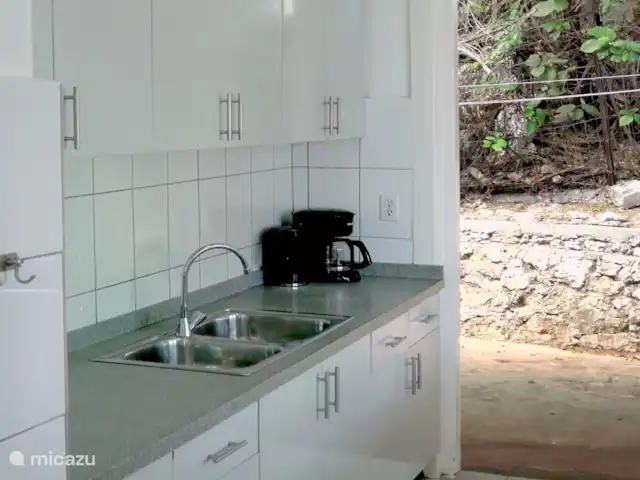 Villa Dushi Bida avec vue sur la mer ! | Curaçao, Curaçao-Centre, Piscadera - villa La cuisine s'ouvre sur le jardin de la terrasse arrière qui donne accès à la piscine, à la deuxième salle de bain extérieure et à la machine à laver.