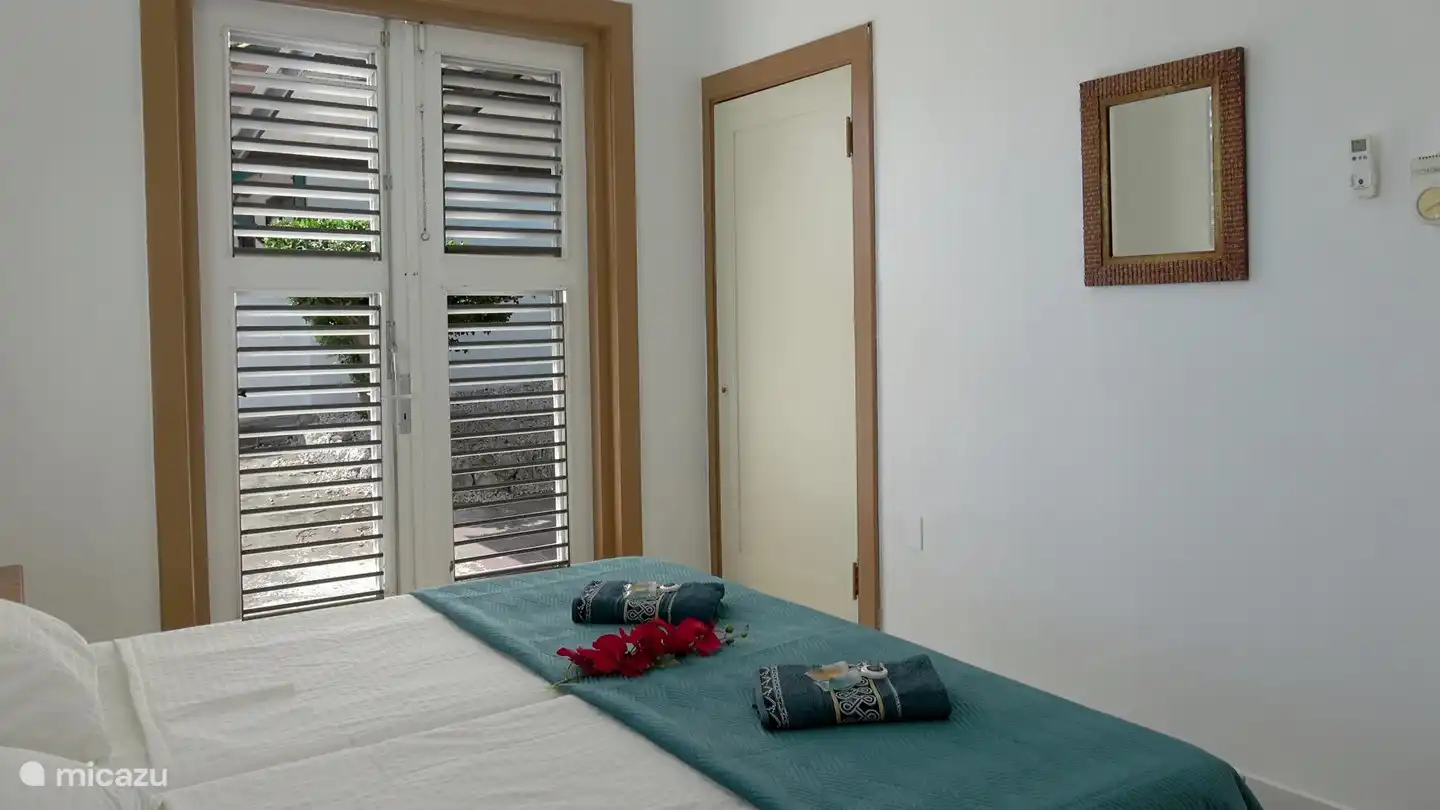 La chambre dispose de la climatisation, d'un ventilateur de plafond et d'une armoire intégrée.