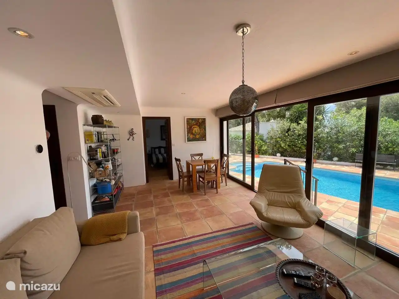 salon au rez-de-chaussée, avec canapé-lit, 2 fauteuils, table à cartes, climatisation et TV