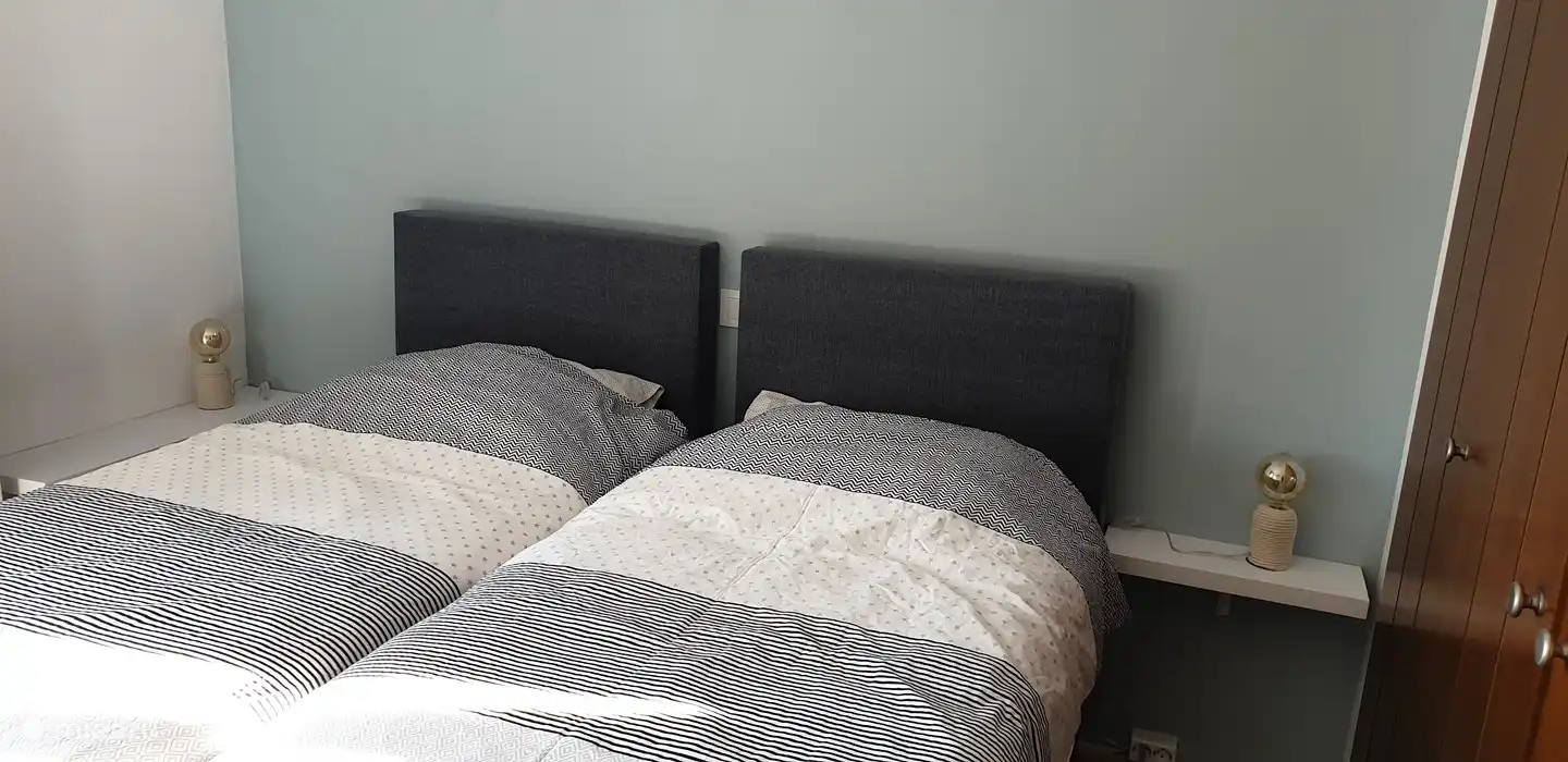 Chambre 1 avec lits à sommier tapissier séparés, ceux-ci peuvent être placés séparément ou ensemble. Aussi une armoire et un accès au balcon.