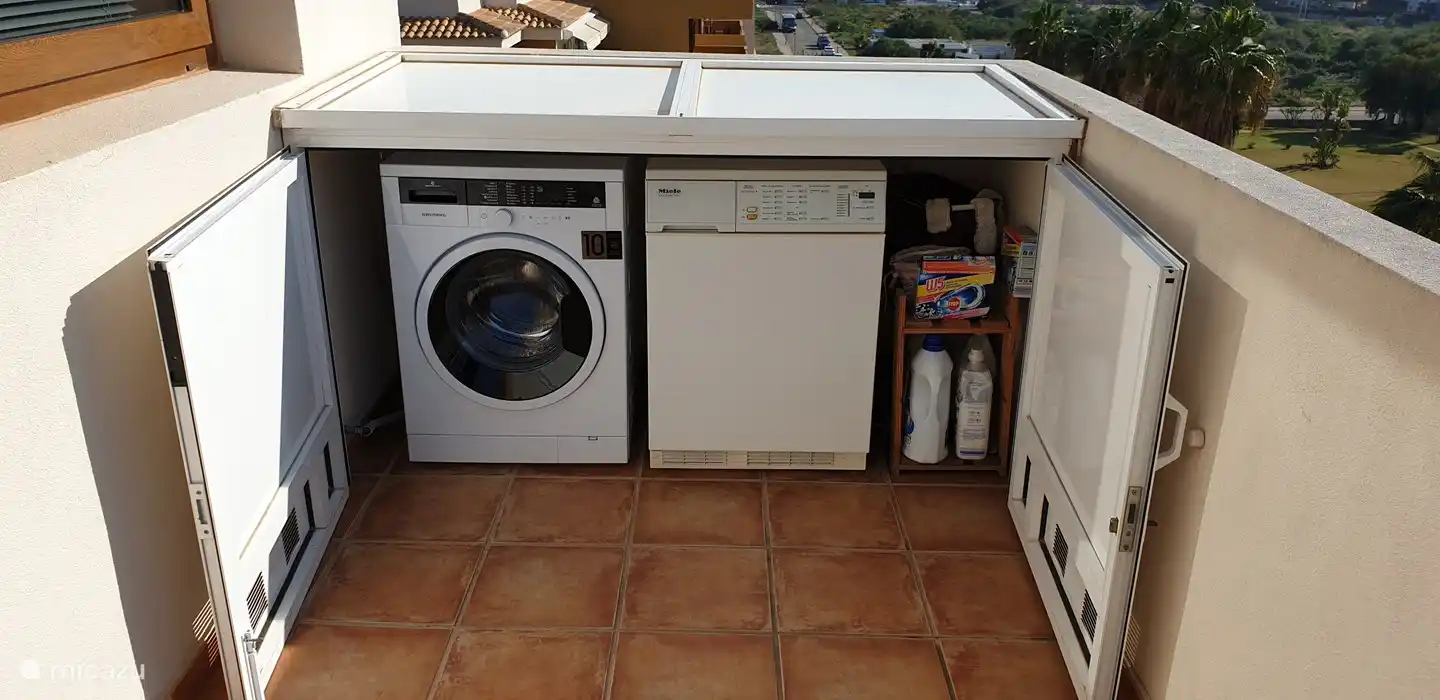 Sur le balcon la machine à laver et le sèche-linge.