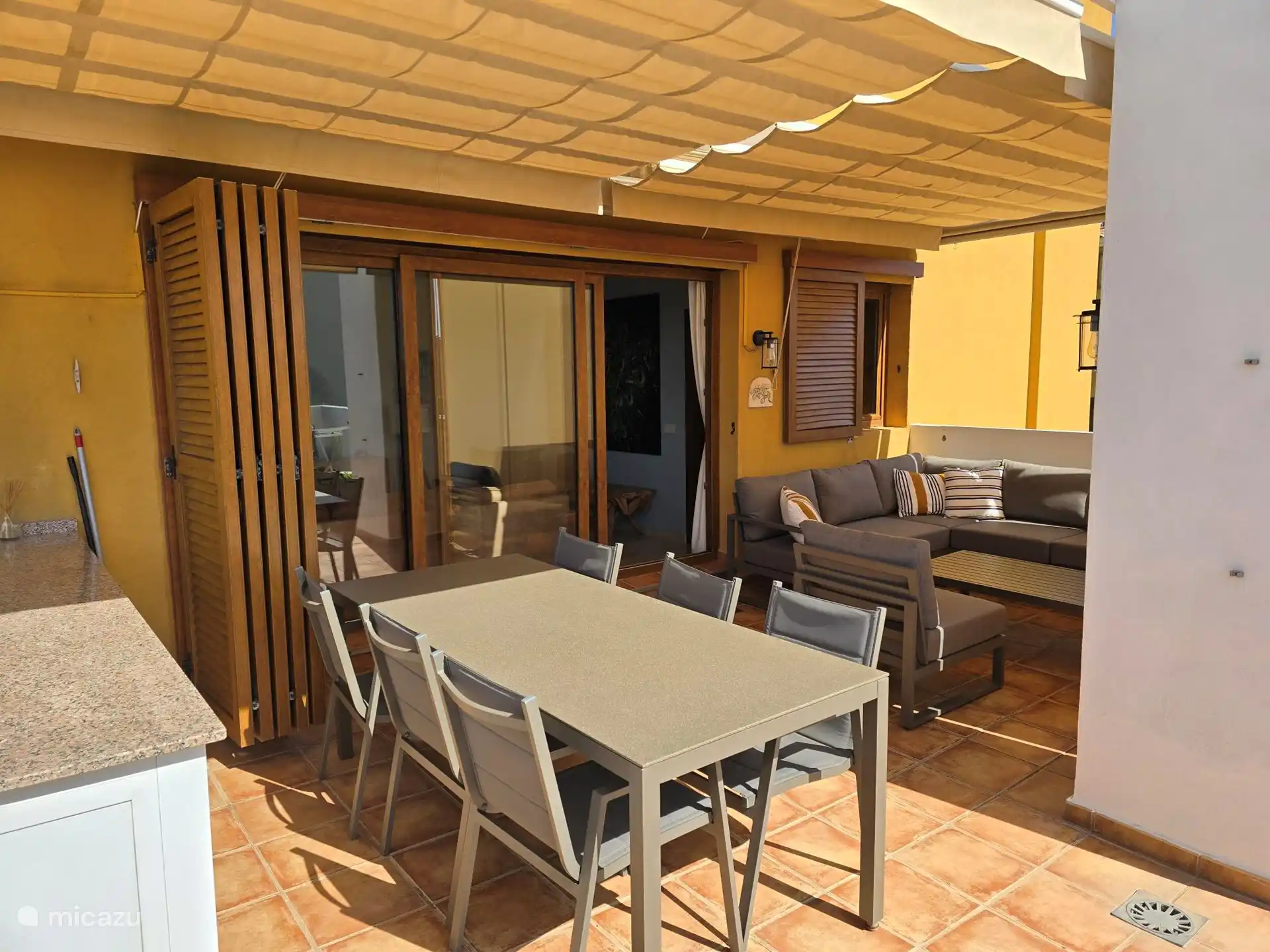 Grande terrasse sur le toit avec salon et table à manger.