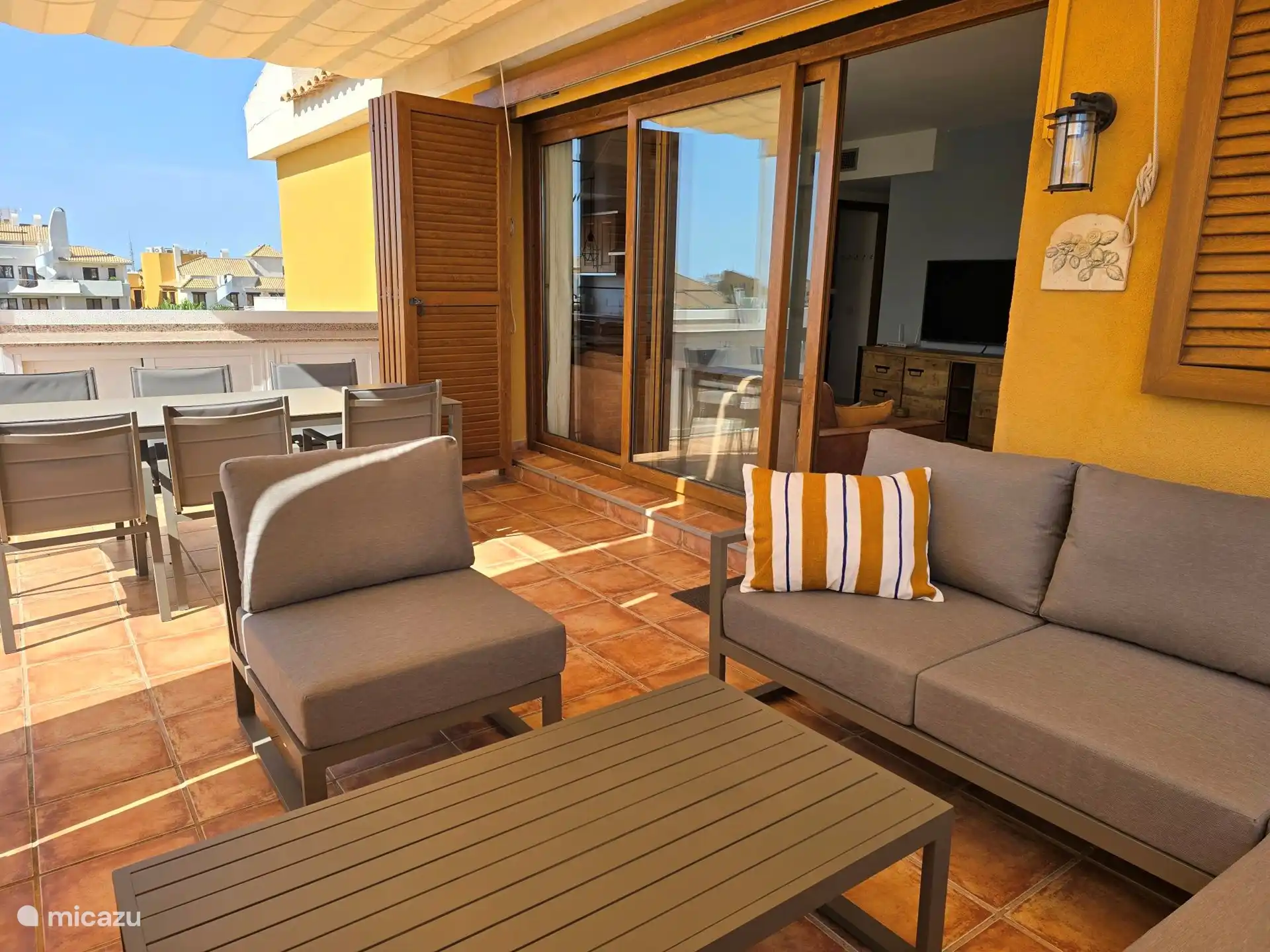 Grande terrasse sur le toit avec salon et table à manger.