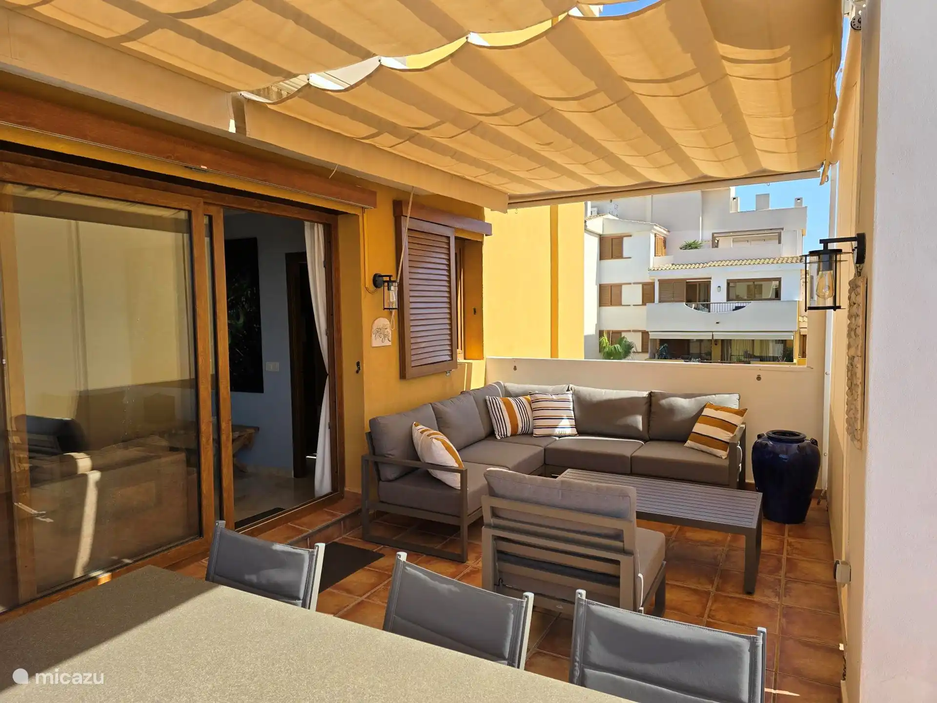 Grande terrasse sur le toit avec salon et table à manger.