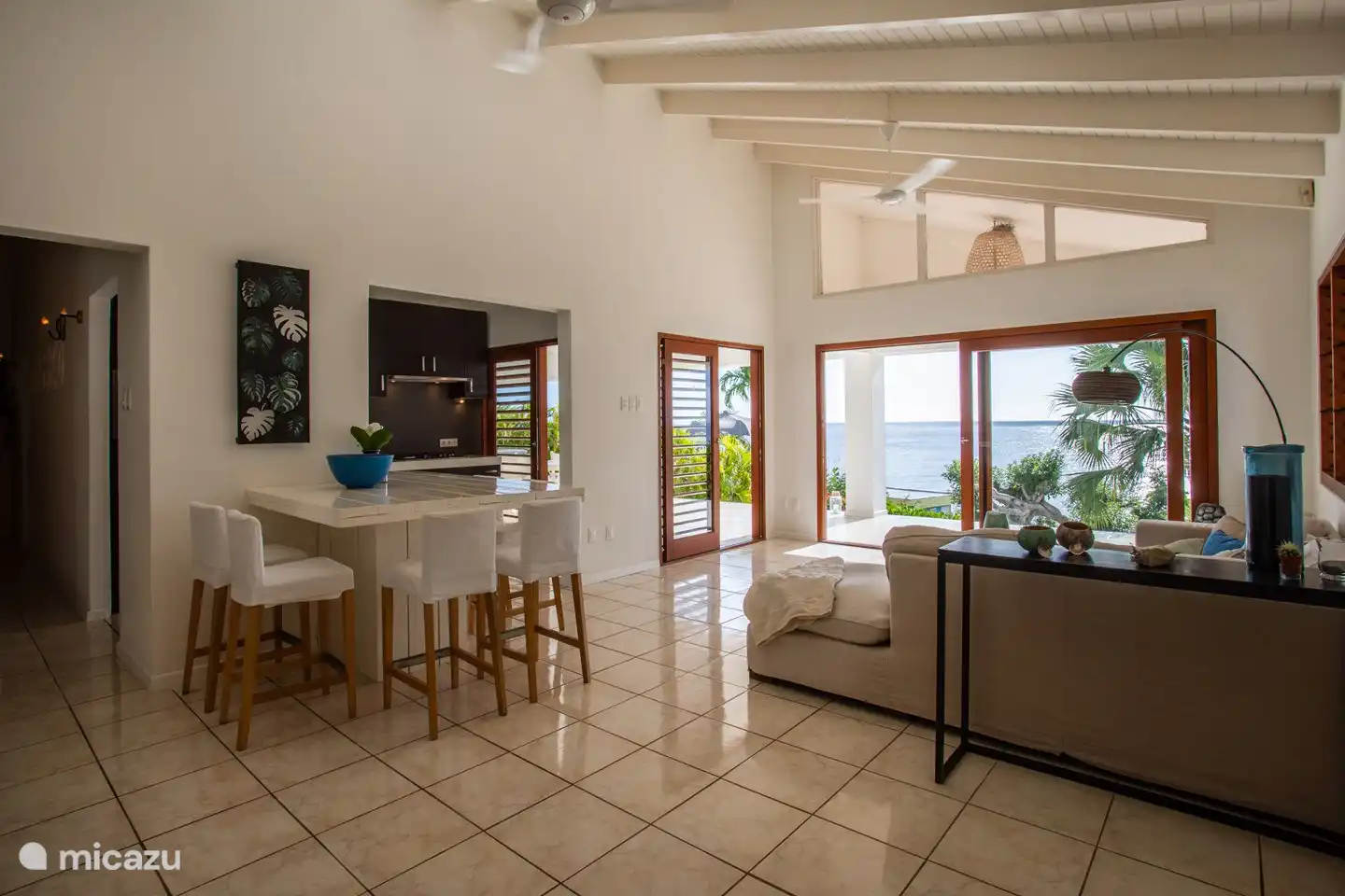 Wohnzimmer mit hohem Esstisch und großen Schiebetüren.