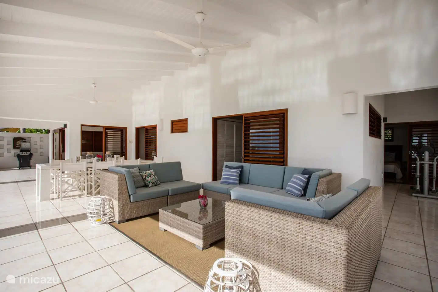 Geräumige, schattige Veranda mit Sitz- und Essbereich und Meerblick.