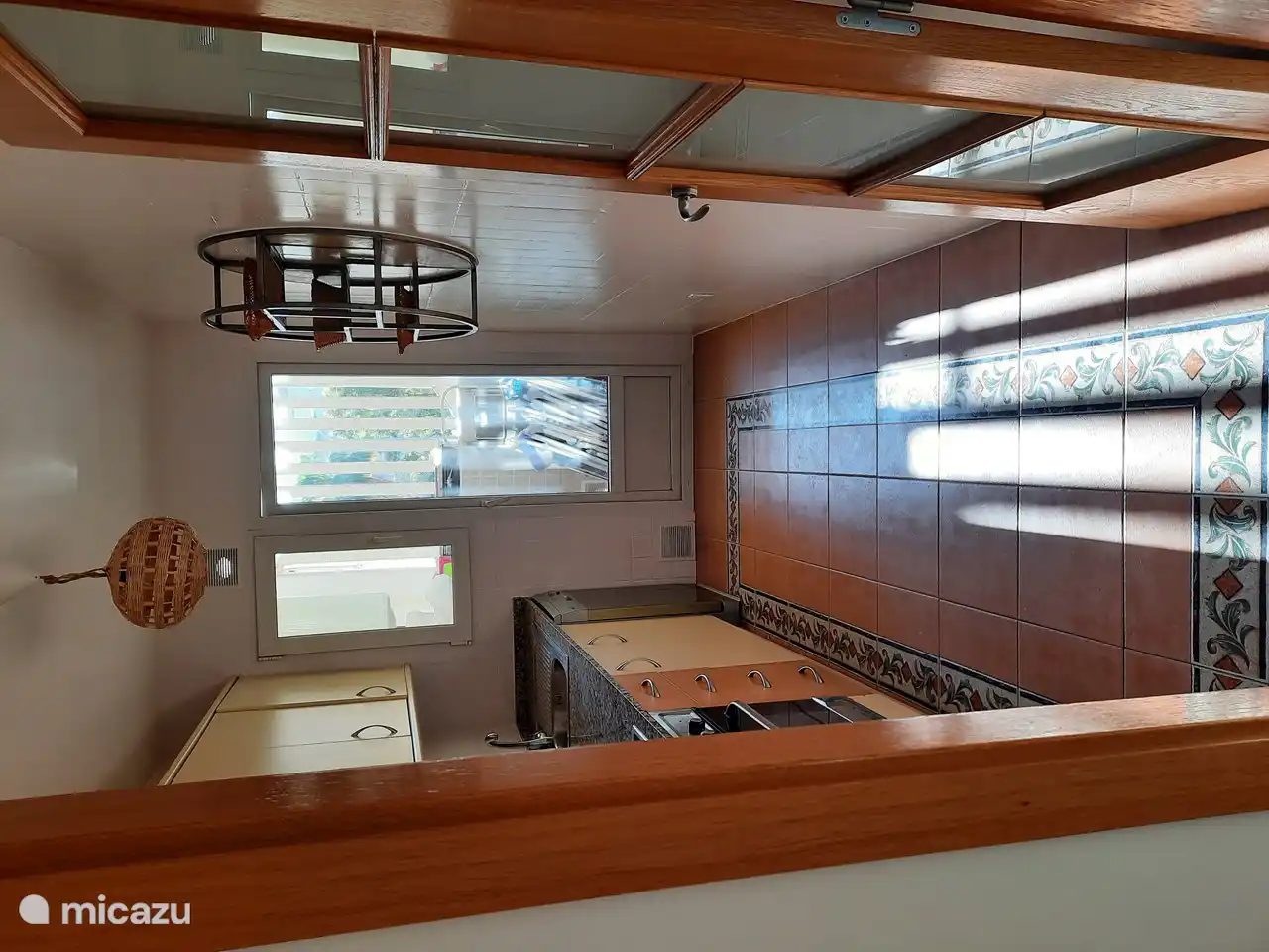 Une cuisine spacieuse avec accès à la buanderie où se trouvent la machine à laver et le sèche-linge.