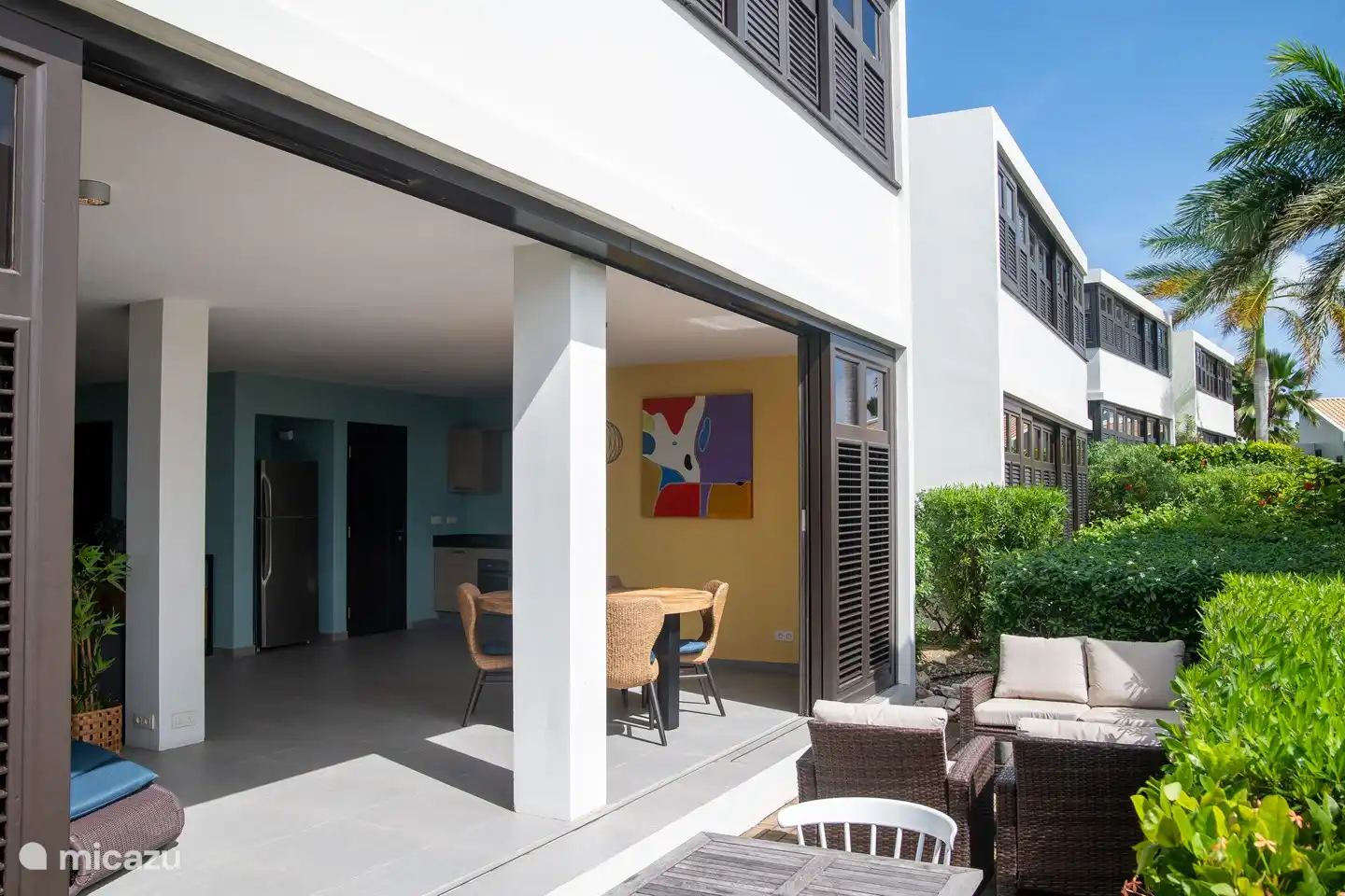 Magnifique coin salon extérieur entouré de plantes tropicales et de palmiers