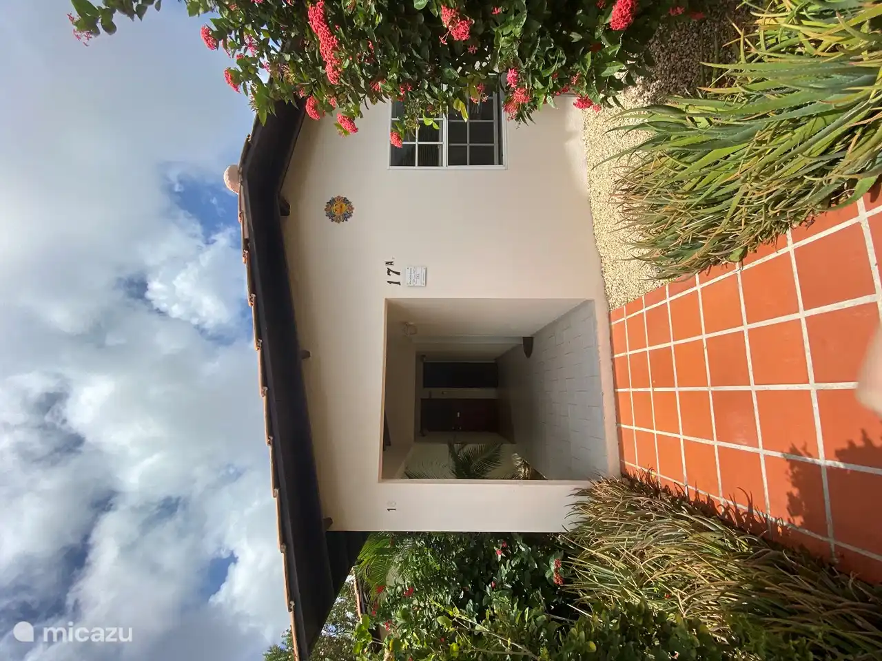 Blue Miles Estate with front bedroom and covered entrance on the right. Also in front garden seating for two.