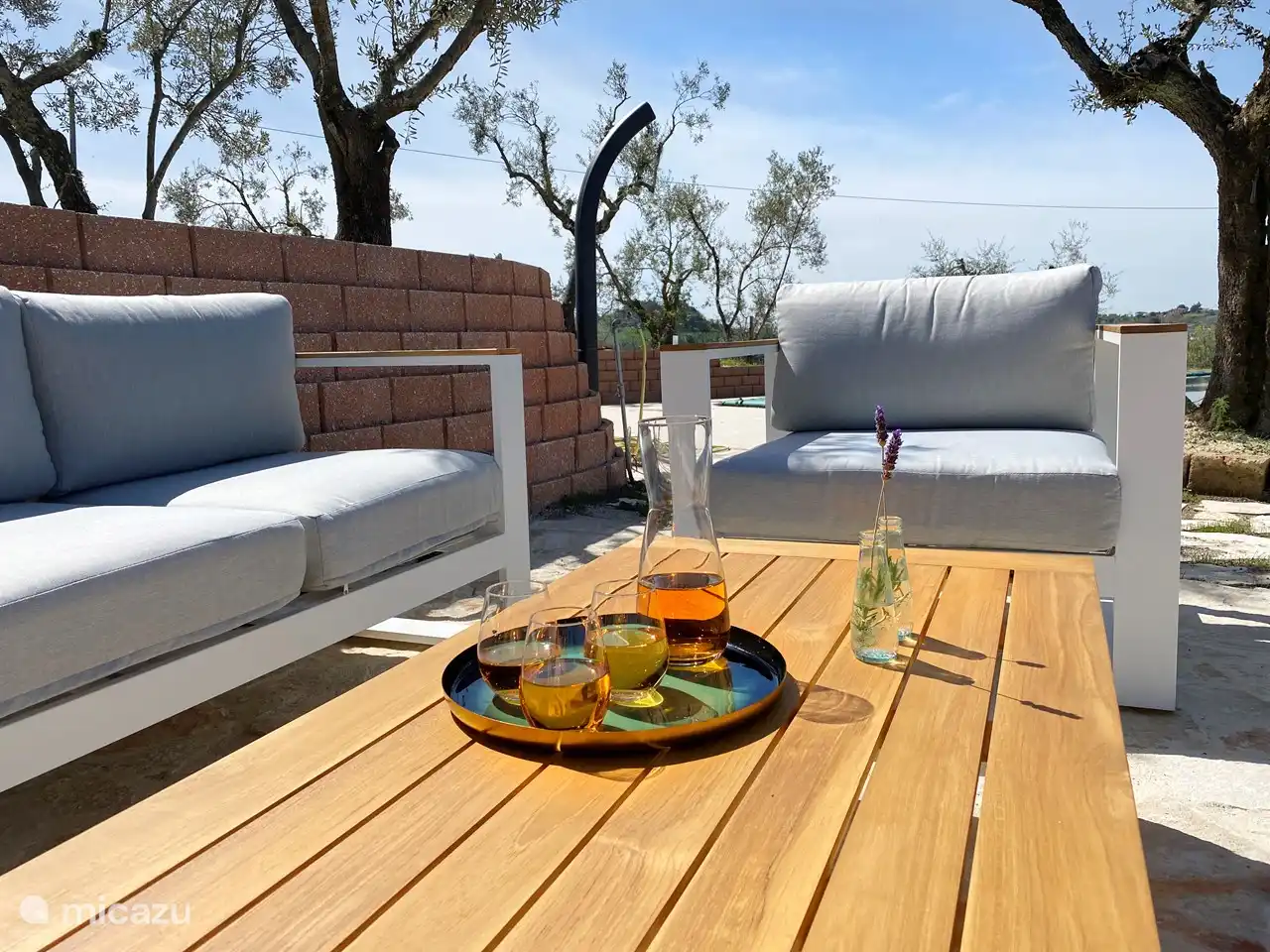 Terraza con salón ambientado junto a la piscina