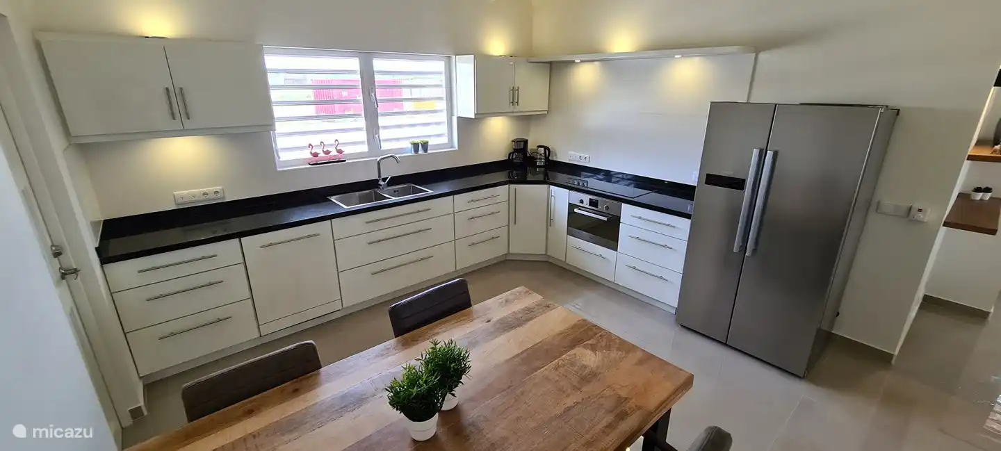 Kitchen with American fridge, induction hob, dishwasher and microwave oven.