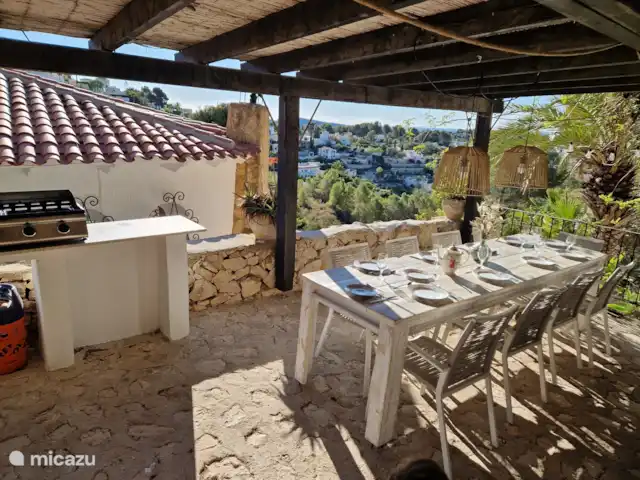 magia de la casa en España, Costa Blanca, Benissa - casa vacacional Terraza cubierta con barbacoa de gas, con mesa grande y sillas bonitas. Con fantásticas vistas al valle y al mar