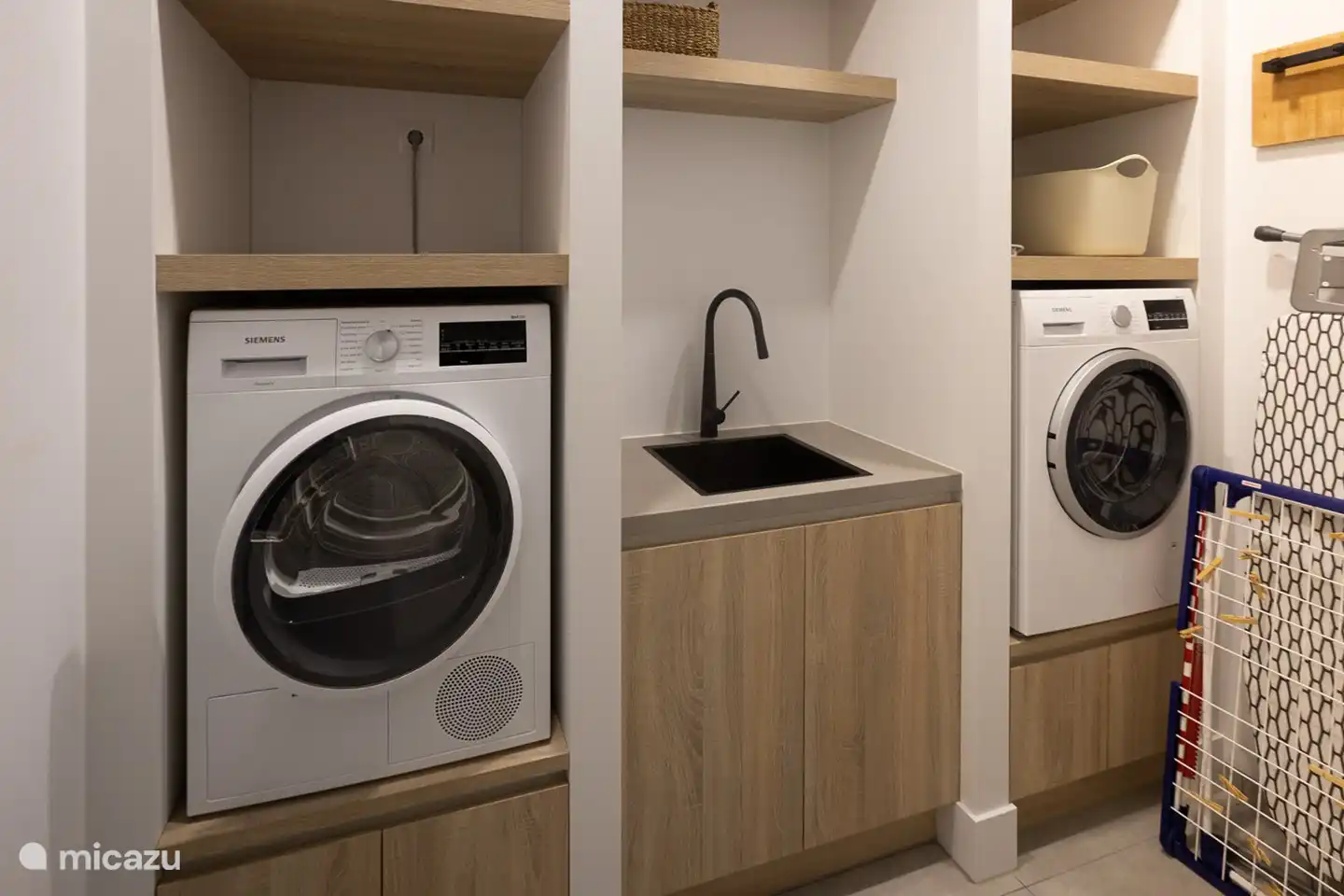 Waschküche mit Waschmaschine, Trockner und Bügelzubehör