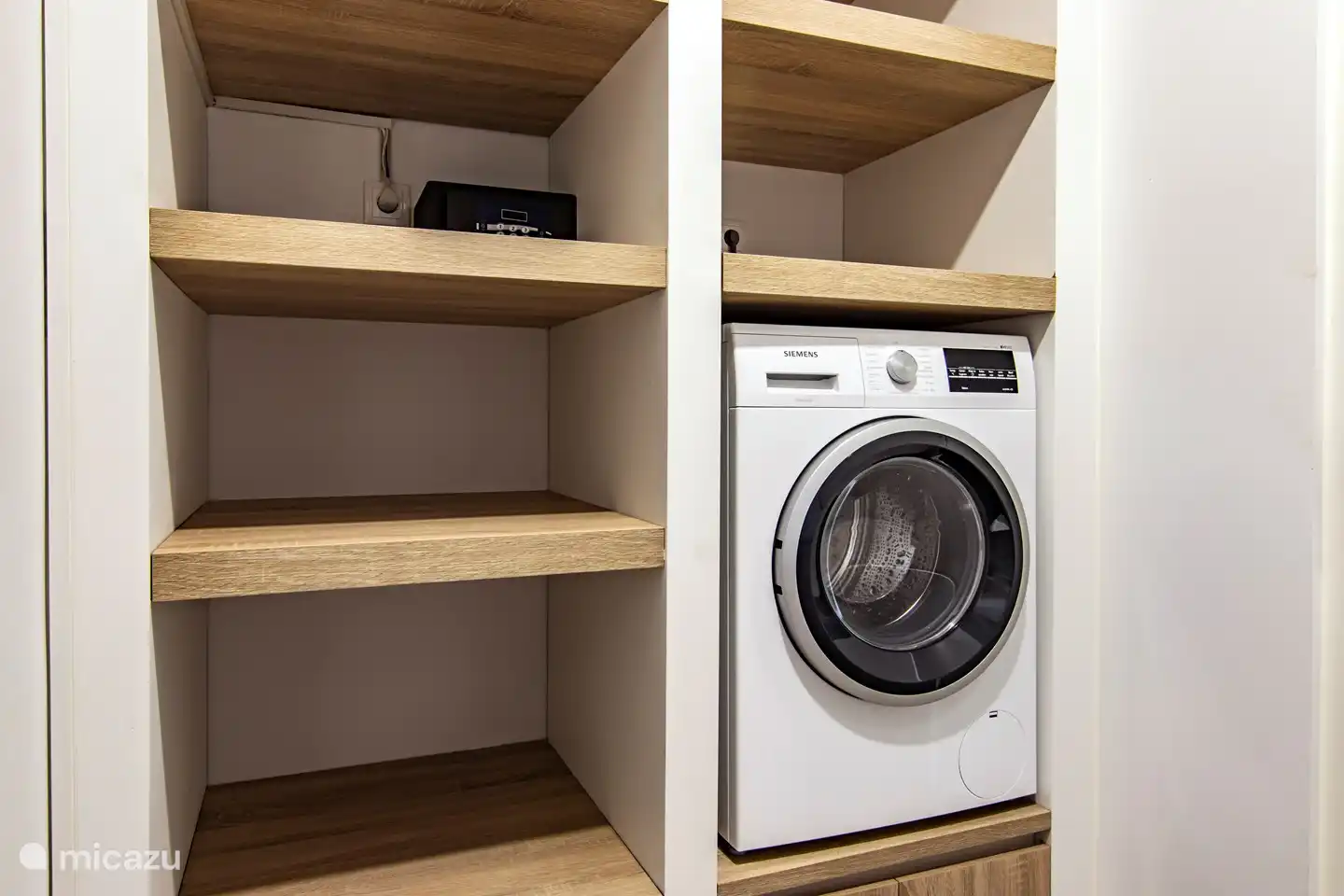 Waschküche mit Waschmaschine und Bügelzubehör