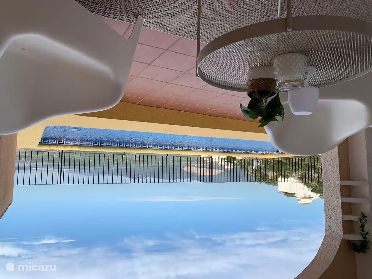 Überdachter Sitzbereich mit Grill am Pool.