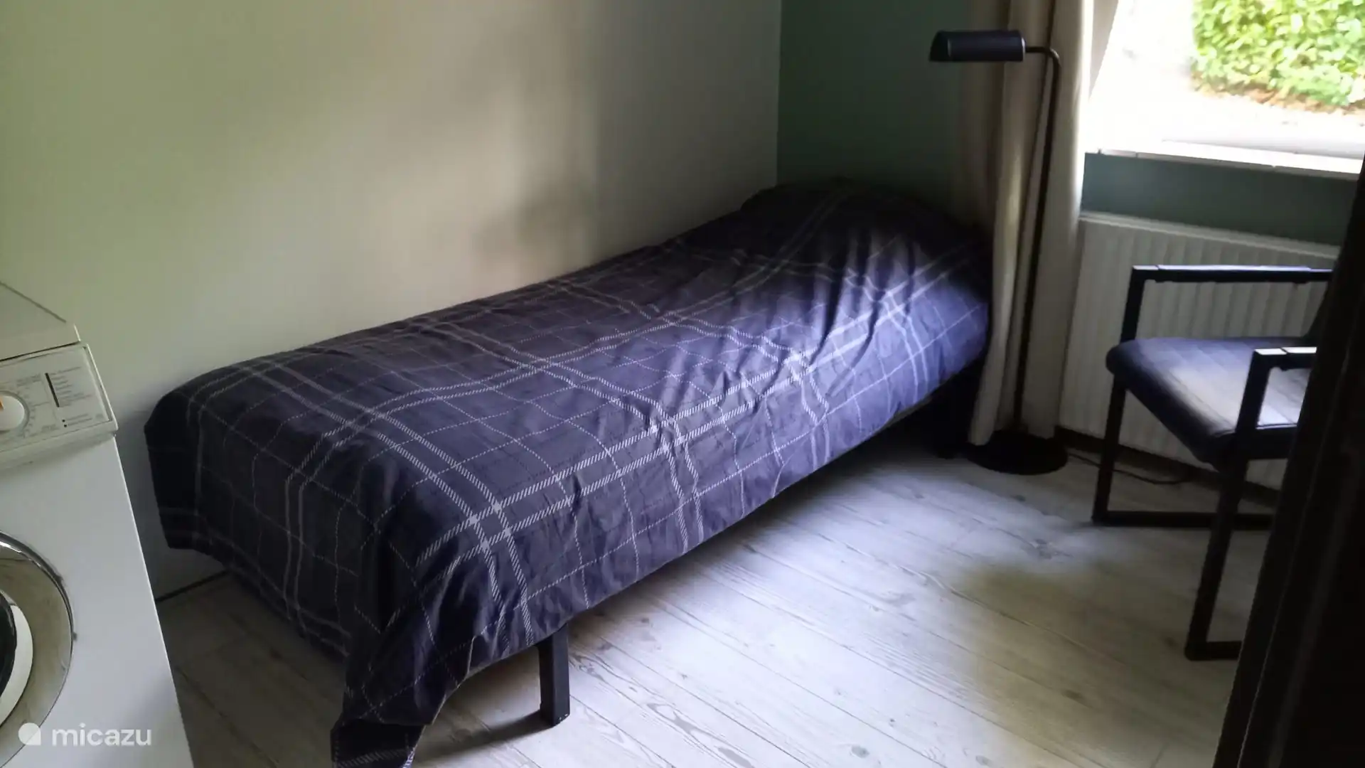 Een kamer met een eenpersoonsbed