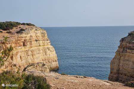 Die felsige Küste der Algarve und der Leuchtturm.