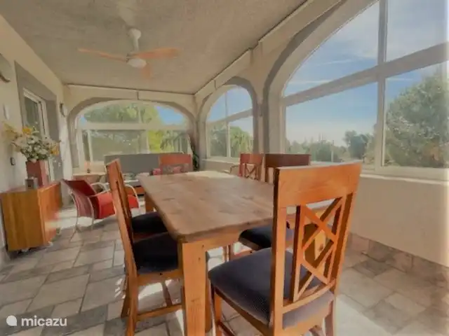 Villa Familia - Près de la mer ! | Espagne, Costa Dorada, L'Ametlla de Mar - villa Séjour 3. Séjour / Véranda de l'appartement 2 (1er étage). La véranda (située au sud-est) est équipée d'une table à manger avec 6 chaises et d'un canapé (couchage). De cette véranda, vous avez une vue sur la piscine et vous pouvez voir la mer Méditerranée au loin.