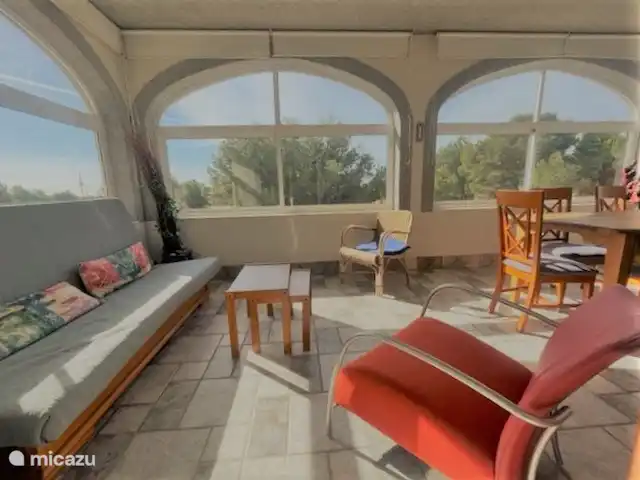 Villa Familia - Près de la mer ! | Espagne, Costa Dorada, L'Ametlla de Mar - villa Séjour 3. Séjour / Véranda de l'appartement 2 (1er étage). La véranda (située au sud-est) est équipée d'une table à manger avec 6 chaises et d'un canapé (couchage). De cette véranda, vous avez une vue sur la piscine et vous pouvez voir la mer Méditerranée au loin.